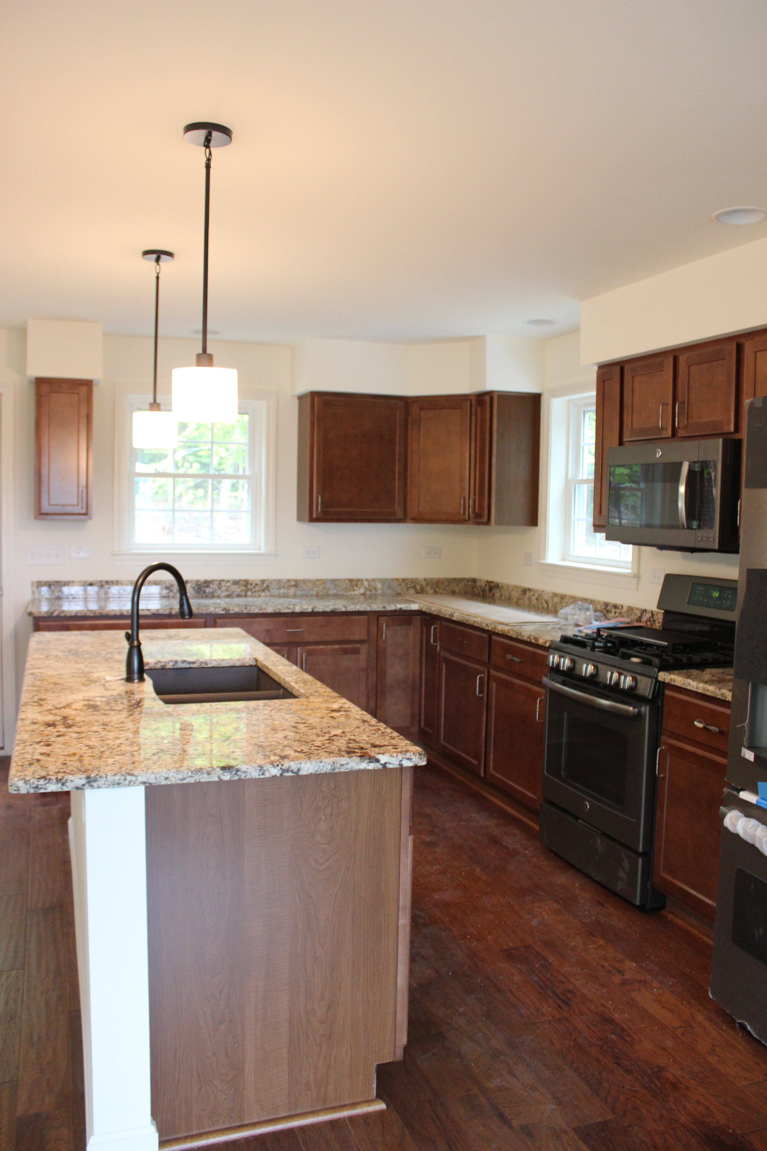 Berzinis kitchen with dark cabinets and granite