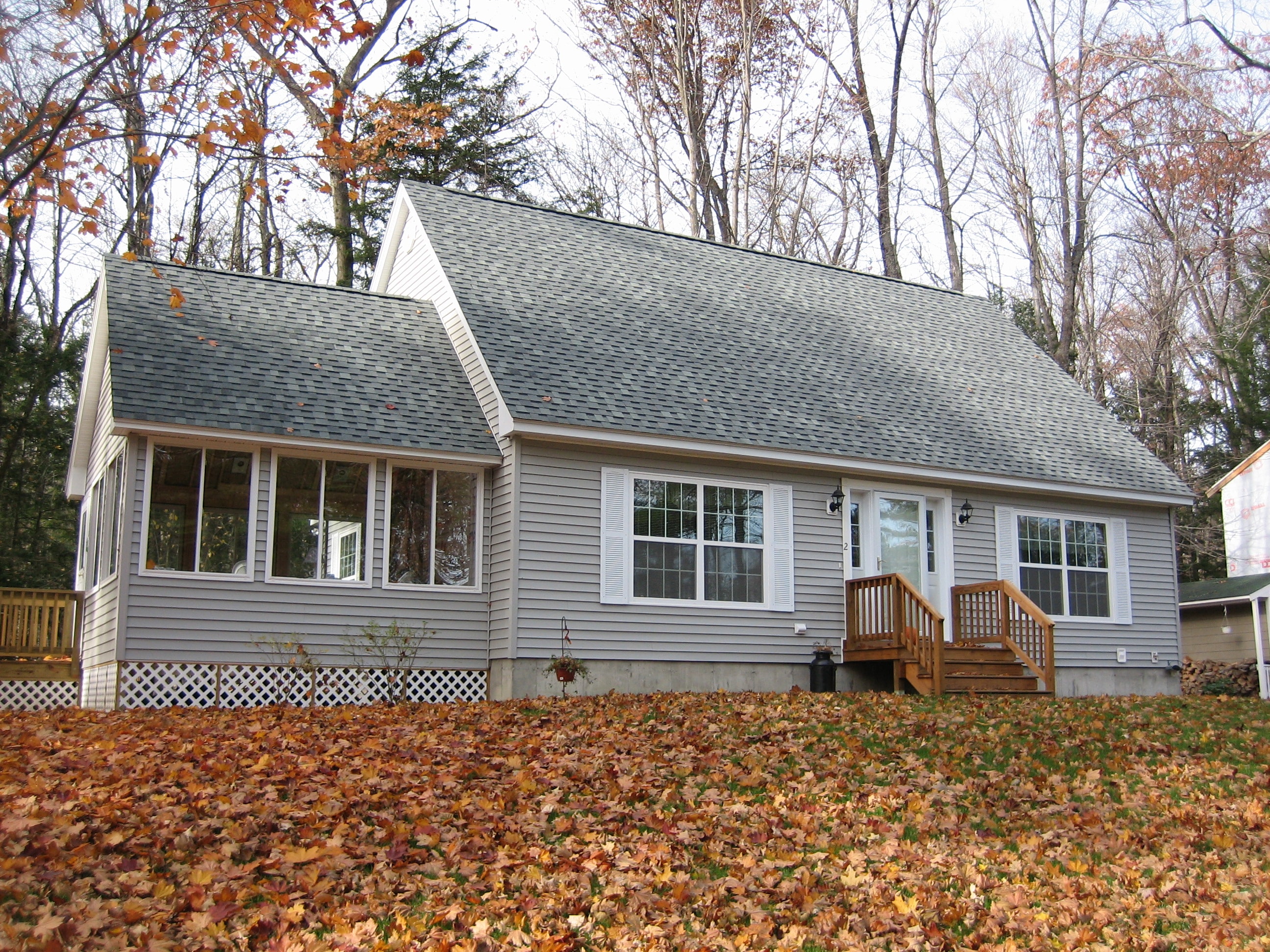 Dionne Cape with gray siding and autumn leaves